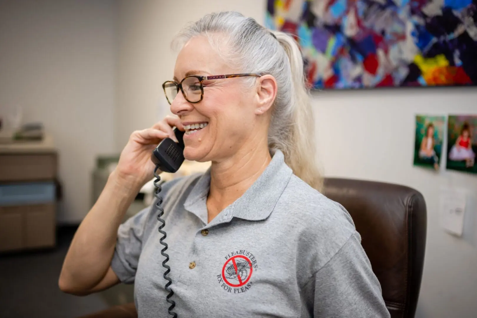 A woman talking on the phone while wearing glasses.