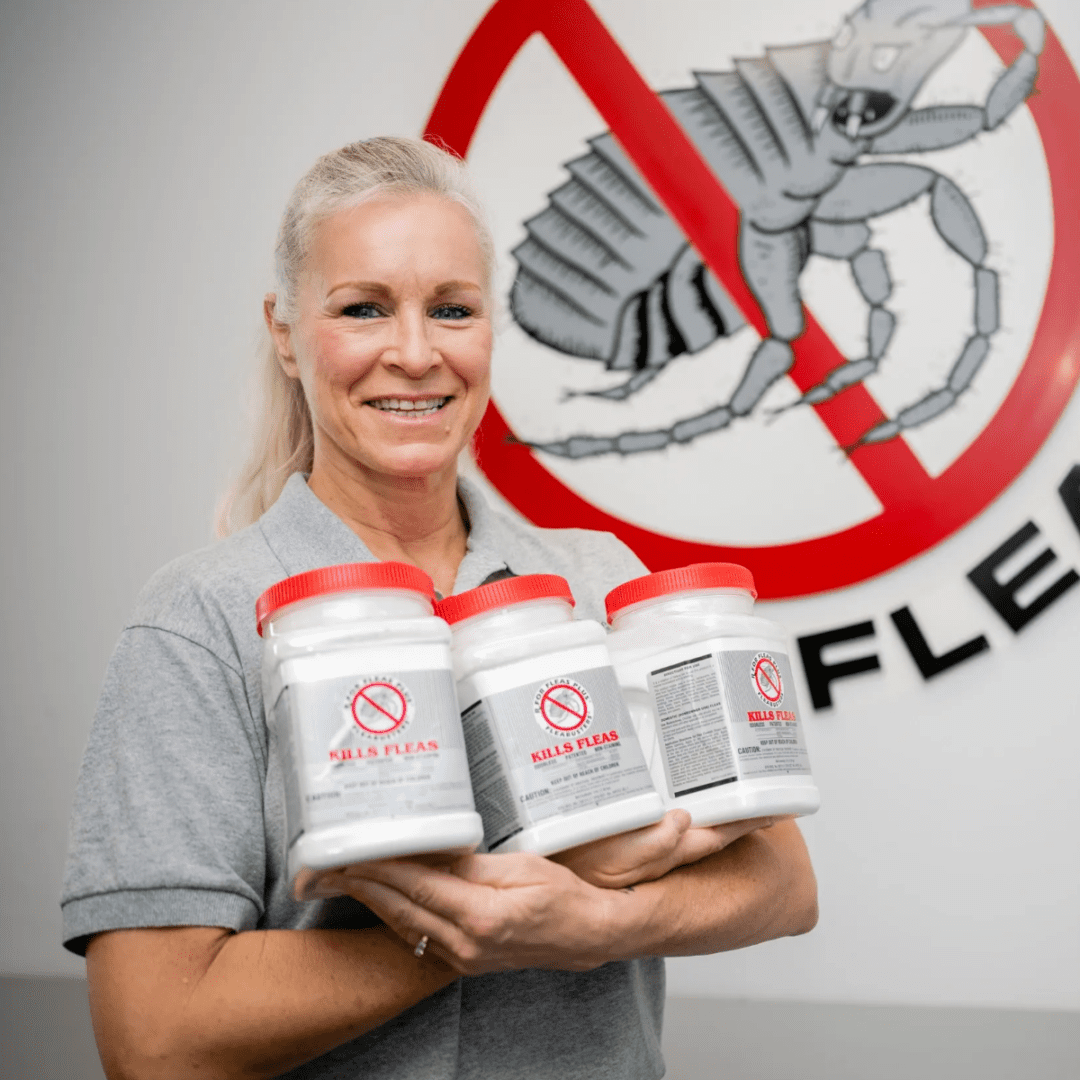 A woman holding three canisters of flea powder.